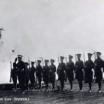 T.L. Kennedy's recruits are photographed in 1914 as they salute the flag during Retreat. Training took place on the Cooksville Fair Grounds.